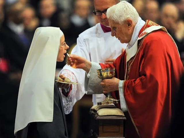 Benediktas XVI dalija šv. Komuniją
